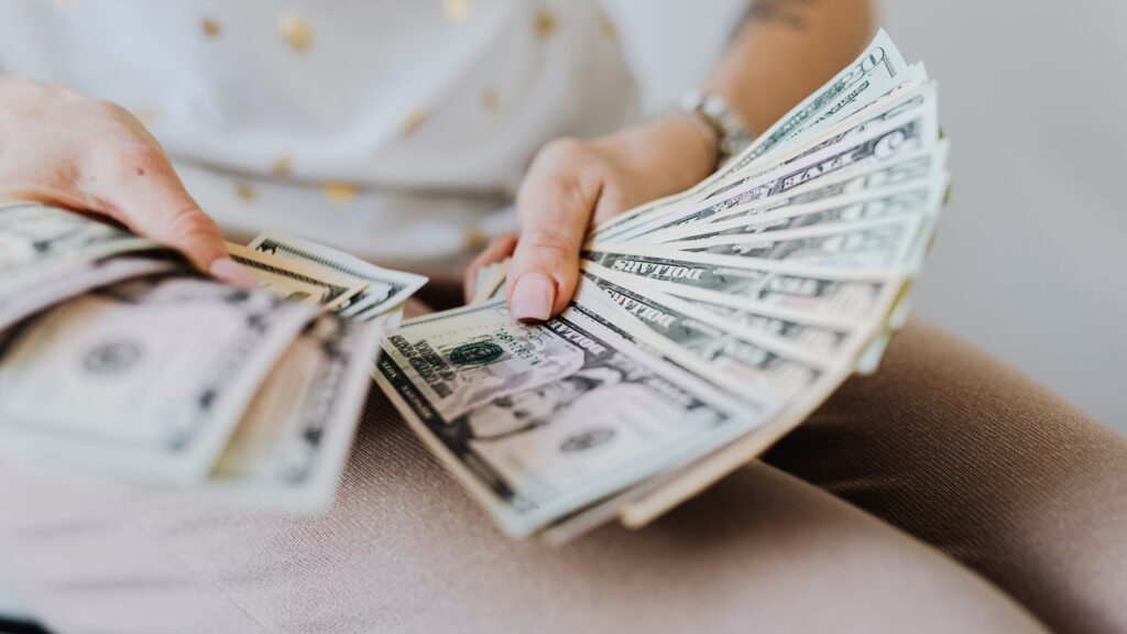 Woman holding a spread out stack of bills